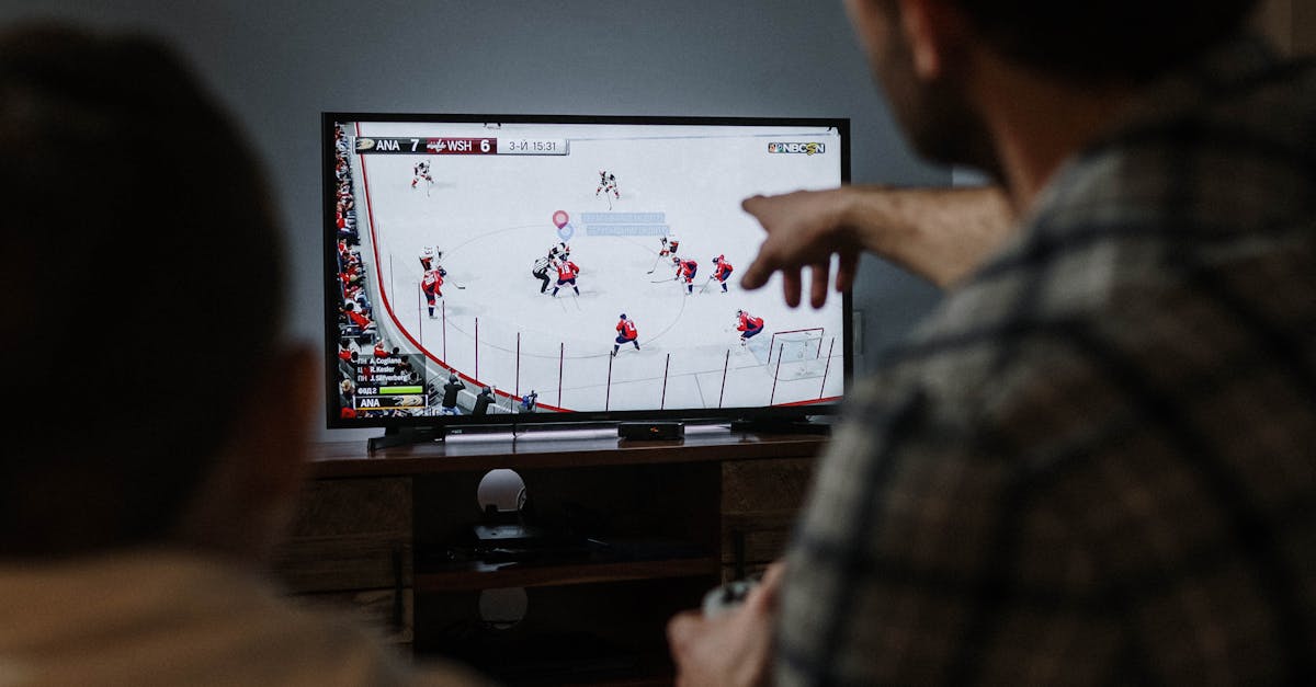 Father and son playing ice hockey video game together at home, fostering family bonding.